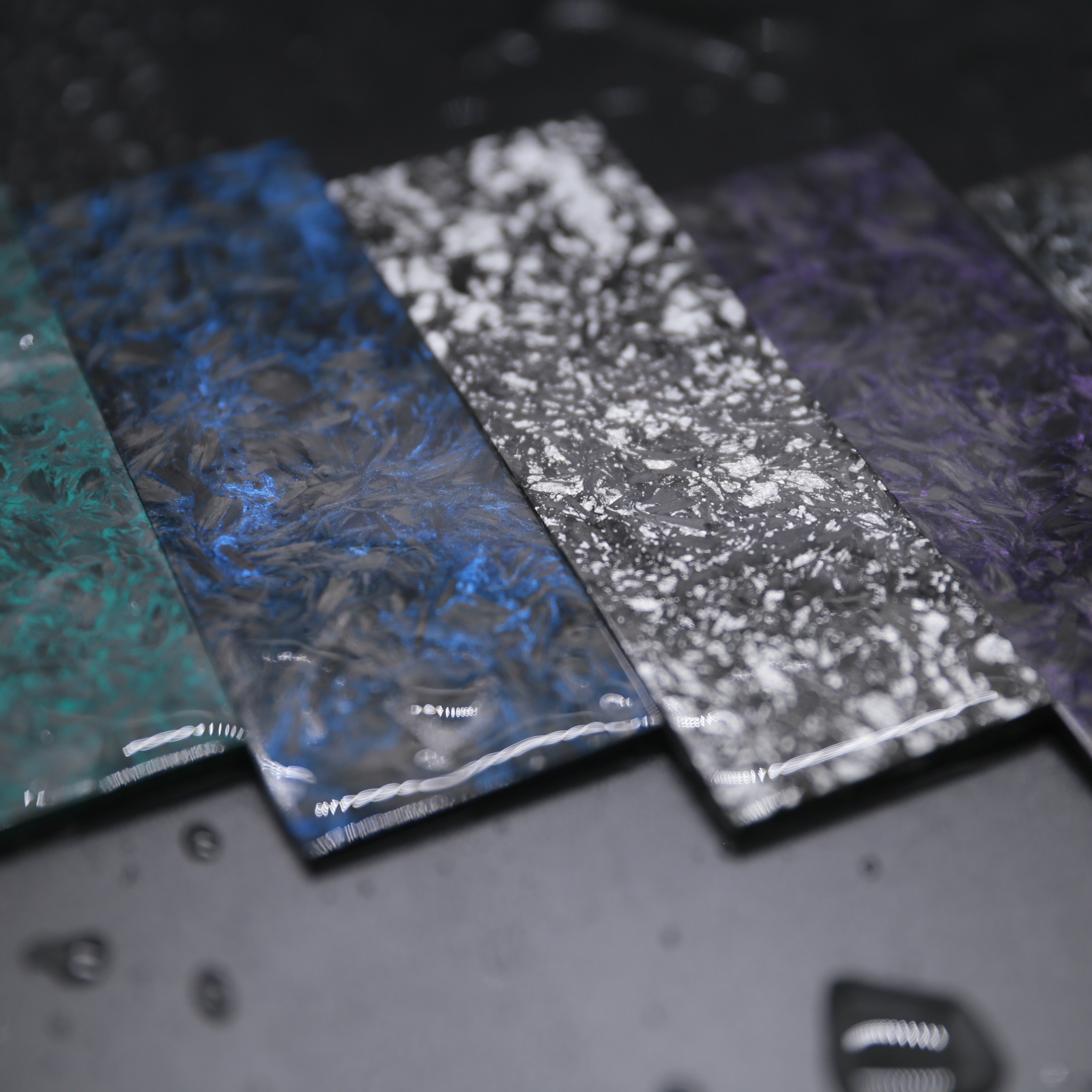 Colored forged carbon fiber material samples showing surface consistency for production